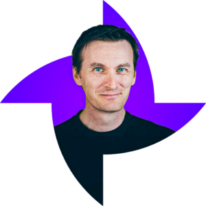 Homme blanc, cheveux courts, yeux bleus, porte un pull noir