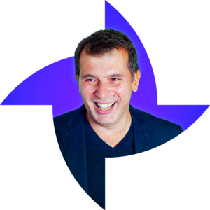 Homme blanc, souriant, cheveux courts bruns, porte un polo et une veste bleus